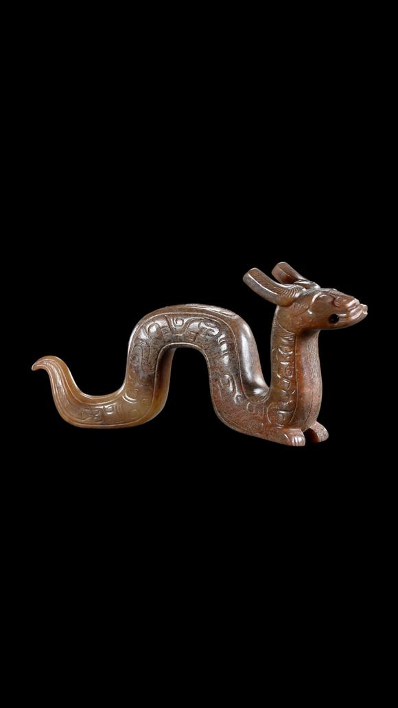 Castle AuctionA Calcified Brown Jade Dragon Pendant, Han, Circa 2nd C BC–2nd C AD Pr.