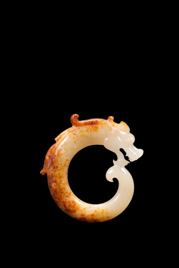 Castle AuctionA White Jade C-Shaped Dragon Pendant with Russet Veins, Han, Circa 2nd C BC–2nd C AD Pr.