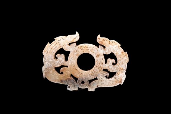 Castle AuctionA Calcified Pale Jade Twin Dragon Openwork Pendant, Han, Circa 2nd C BC–2nd C AD Pr.