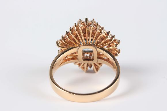TooveysA gold, blue topaz and diamond cluster ring, claw set with the cut cornered square cut blue topaz within a surround of marquise, baguette and circular