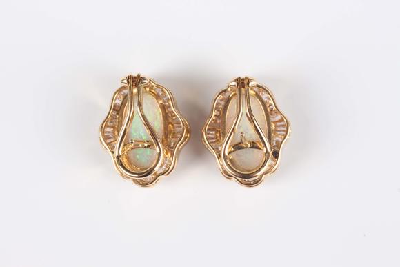 TooveysA pair of gold, opal and diamond shaped oval earrings, each collet set with the oval opal within a surround of tapered baguette and circular cut diamo