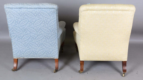 TooveysA near pair of late Victorian Howard & Sons armchairs, each buttoned back above scroll arms, on turned walnut legs with gilt brass caps and castors, e
