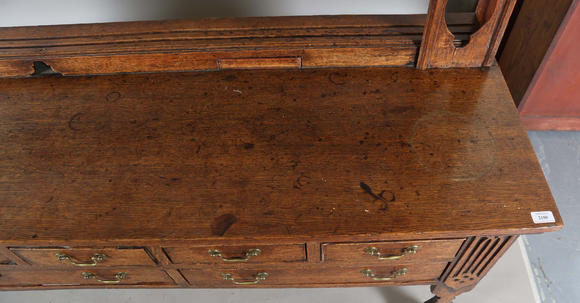 TooveysA good George III North Country oak dresser, the plate rack with pierced side panels above a lappet carved frieze and an arrangement of nine drawers,