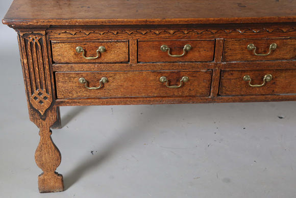 TooveysA good George III North Country oak dresser, the plate rack with pierced side panels above a lappet carved frieze and an arrangement of nine drawers,