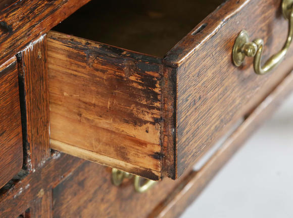 TooveysA good George III North Country oak dresser, the plate rack with pierced side panels above a lappet carved frieze and an arrangement of nine drawers,