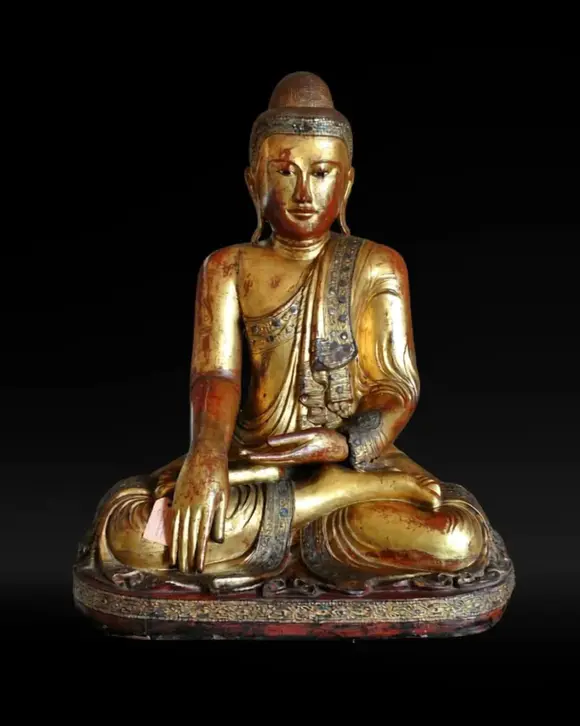 Bertolami Fine ArtBuddha figure in the lotus position. Lacquered and gilded wood with stucco and glass paste applications, set on a wooden and black lacquer base. Burma, Mandalay, 19th century.