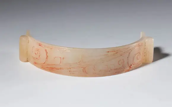 Bertolami Fine ArtSemicircular ornament in archaic style in engraved jade. Two cicada-shaped elements at the ends. Traces of red pigment in the engravings. China, Qing dynasty (1644–1912), late 19th century