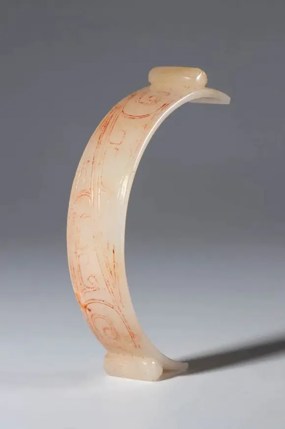 Bertolami Fine ArtSemicircular ornament in archaic style in engraved jade. Two cicada-shaped elements at the ends. Traces of red pigment in the engravings. China, Qing dynasty (1644–1912), late 19th century