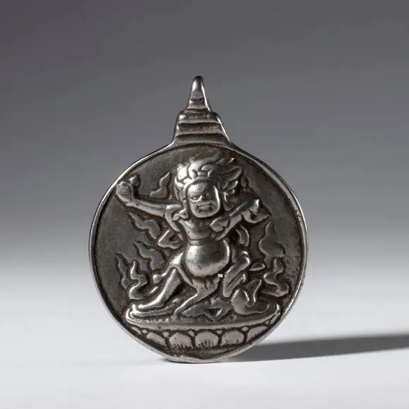Bertolami Fine ArtJiu Gong Ba Gua amulet, made of silver alloy with a depiction of Mahakala. Tibet, 20th century
