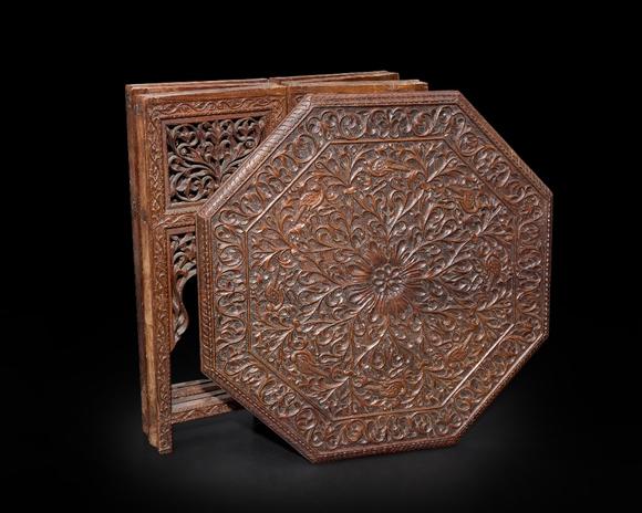 RoseberysAn octagonal carved wood table,?
Madras, India, mid-19th century

The table top fitting onto the hinged folding base, deeply carved to top with a