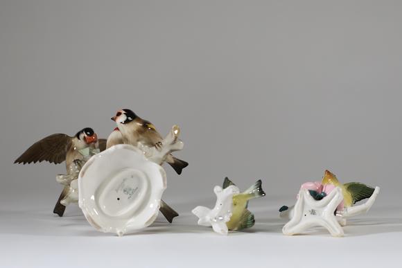 Goldfield Auction sarlsLot de trois sujets animaliers en porcelaine polychrome figurant des oiseaux branchés, comprenant un groupe de chardonnerets et deux petits oiseaux su