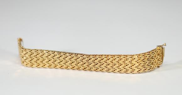 Goldfield Auction sarlsBracelet manchette en or jaune à décor ajouré et articulé, composé de multiples rangs de maillons géométriques finement travaillés, fermoir intégré. T
