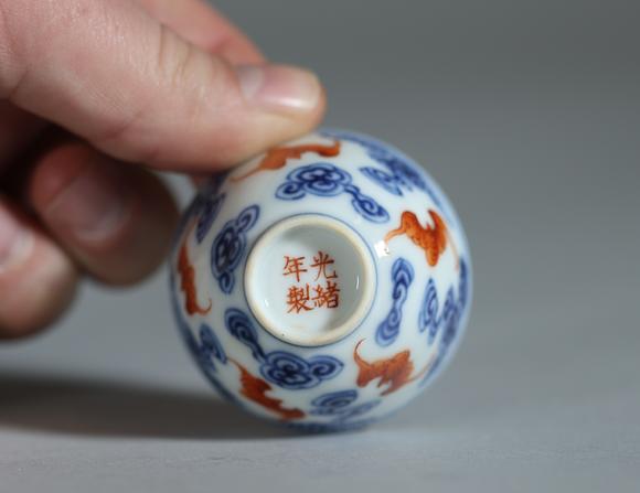 Goldfield Auction sarlsChine, ensemble de quatre petits bols en porcelaine à décor en bleu sous couverte et rouge de fer de chauves-souris évoluant parmi des nuages stylisés