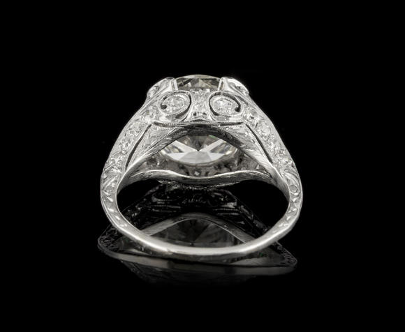 Piguet - H?tel des VentesBague Art Déco platine centrant un diamant taille brillant entouré de diamants taille demi-lune et 8/8 ainsi que d'émeraudes calibréesArt Déco platinum ring set with one center diamond, half-moon and 8/8 cut diamonds and calibrated-cut emeralds