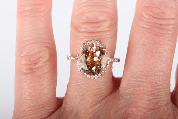 TooveysAn 18ct gold, morganite and diamond oval cluster ring, claw set with