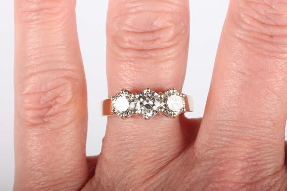 TooveysAn 18ct gold and diamond three stone ring, claw set with a row of ci