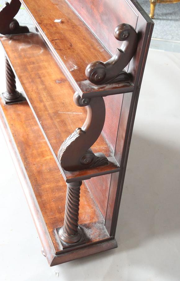 TooveysAn early Victorian mahogany three-tier graduated bookshelf with scro