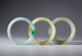 A lot of three ornamental bracelets in light jade and green jade. China, Qing Dynasty (1644–1911), 19th century.