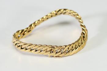 Bracelet gourmette ? Caplain Paris ? en or jaune, composé de larges maillons plats et articulés, fermoir mousqueton orné d’un cabochon de saphir bleu