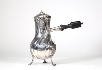 Grande chocolatière en argent massif reposant sur trois pieds cambrés, à décor de c?tes torses et appliques rocaille, bec verseur feuillagé, couvercle