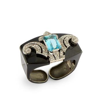 A late Art Deco aquamarine and diamond clip, with detachable later hinged bangle, the clip set with a rectangular mixed-cut aquamarine, estimated as a