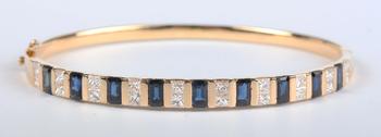 A gold, sapphire and diamond bangle, mounted with a row of nine cut