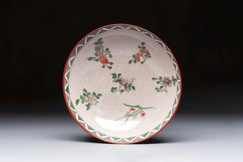 An unusual Chinese famille verte copper-red-ground shallow bowl with floral design, 19th C.